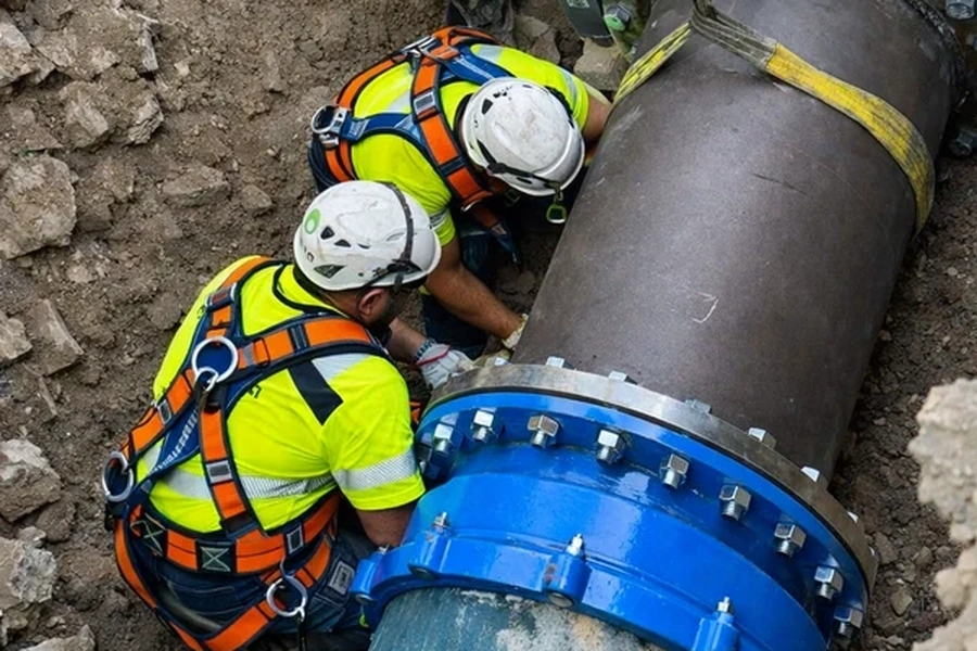 Cantiere pellico e operai nello scavo