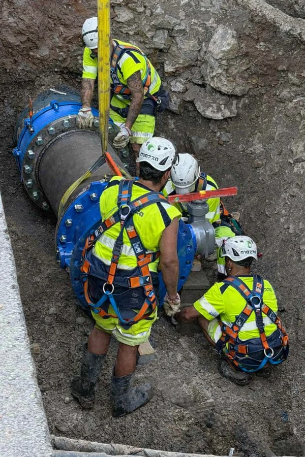 Cantiere pellico operai nello scavo e tubo