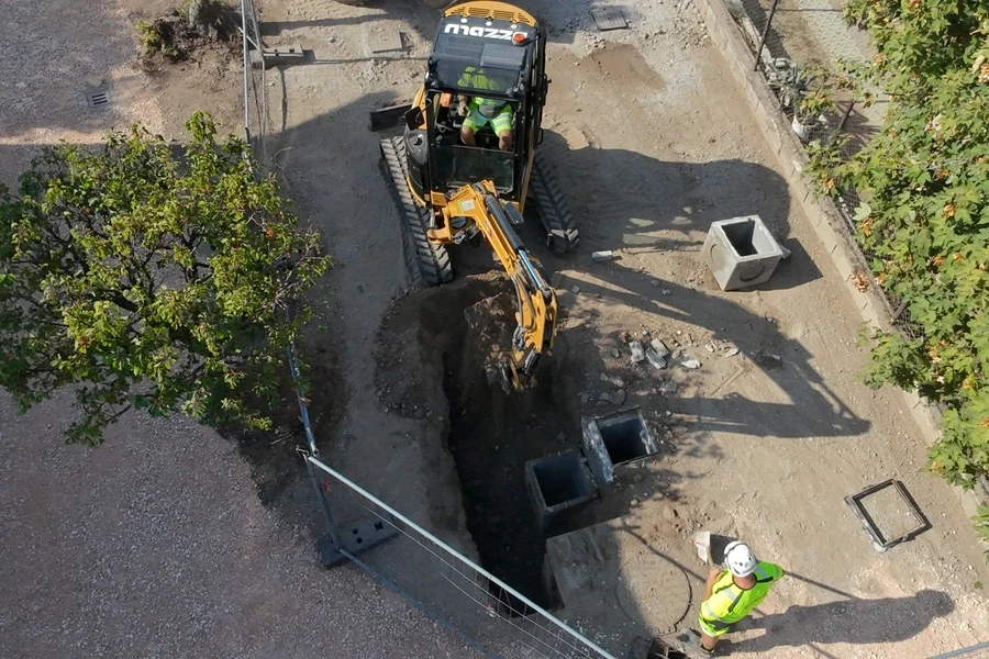 Cantiere leno con escavatore e manovale